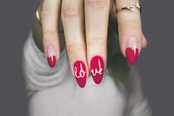 Nail art rojo con letras pintadas a mano